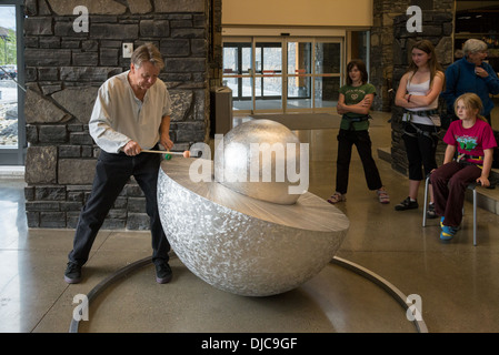 Scultore Tony Bloom gioca tamburo di metallo la scultura a artspeak, luogo di elevazione centro ricreativo, Canmore, Alberta, Canada Foto Stock