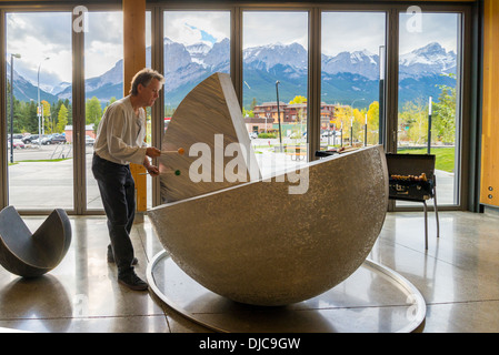 Scultore Tony Bloom gioca tamburo di metallo la scultura a artspeak, luogo di elevazione centro ricreativo, Canmore, Alberta, Canada Foto Stock