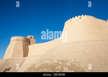 Akshi Bobo, una torre di Kunya Ark, sulla sinistra, e la parete esterna del Ichan Kala, Khiva, Uzbekistan Foto Stock