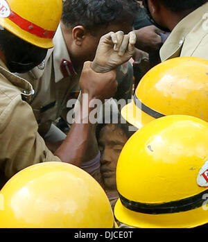 Bangalore, India. 26 Nov, 2013. Vigili del fuoco indiano estrarre un gravemente ferito vittima dai detriti di una casa crollata a Bangalore, India, nov. 26, 2013. Almeno quattro persone sono state uccise dopo un edificio scolastico crollato in Bangalore del sud dello stato indiano del Karnataka Martedì, secondo i media locali relazione. Credito: Stringer/Xinhua/Alamy Live News Foto Stock