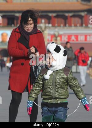 Pechino, Cina. 27 Nov, 2013. Un giovane ragazzo mantiene caldo come visitare la Piazza Tian'anmen a Pechino Capitale della Cina, nov. 27, 2013. Un forte fronte freddo spazzato delleuropa centrale e orientale e la Cina, portando i forti venti e punto di congelamento in temperatura a Pechino mercoledì. Credito: Xing Guangli/Xinhua/Alamy Live News Foto Stock