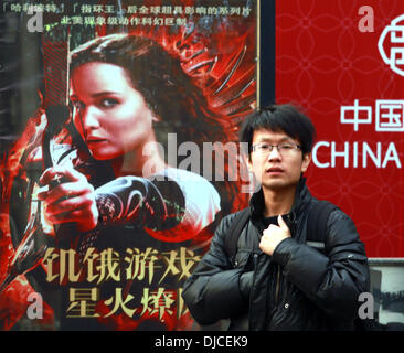 Nov. 23, 2013 - un uomo cinese passeggiate passato un poster pubblicitari le date di apertura della nuova fame film giochi a Pechino il 23 novembre 2013. Tutti i film nazionali e stranieri, mostrato in Cina devono essere presentati al governo centrale per la revisione e l'approvazione, con molti essendo modificati per montare la Cina censura politiche. (Credito Immagine: © Stephen rasoio/ZUMAPRESS.com) Foto Stock