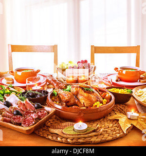 La Giornata del ringraziamento a cena, gustoso pollo cotto sul fulcro della tavola festiva, salumi, a lume di candela, biglietto di auguri Foto Stock
