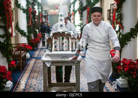 Pinehurst, North Carolina, Stati Uniti d'America. 25 Nov, 2013. SARAH BORRIES, diritto, pasticceria al supervisore e lo Chef JOEY NOROMBABA, resort pasticcere, spostare il villaggio di Pinehurst Cappella giù per un corridoio a La Carolina Hotel. Il villaggio di finito è compreso di panpepato, zucchero e pastillage raffiguranti iconico Edificio nel villaggio di Pinehurst. Credito: Timothy L. Hale/ZUMA filo/ZUMAPRESS.com/Alamy Live News Foto Stock