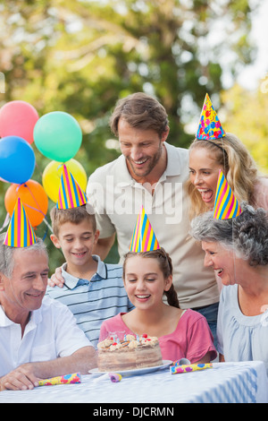 Famiglia allegra indossando party hat mentre festeggia il compleanno Foto Stock