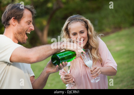 Laughing Man versando champagne per il suo partner Foto Stock