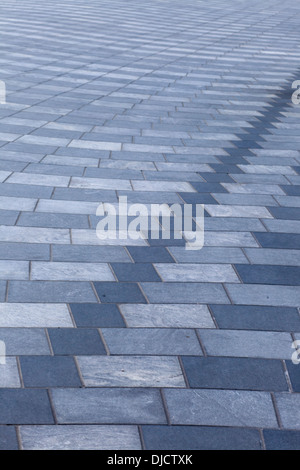 Grigio e bianco strisce ondulate di curva square pavimentazione in pietra Foto Stock