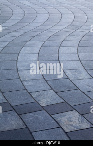 Grigio e bianco strisce ondulate di curva square pavimentazione in pietra Foto Stock