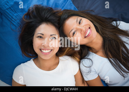 Due giovani donne giacente su un letto Foto Stock