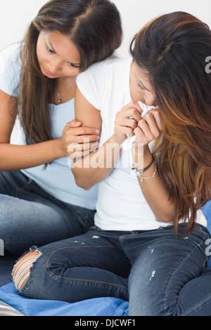 Sconvolta donna che piange e di essere confortati dalla sorella Foto Stock