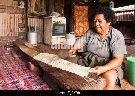 Utelaite Leba rendendo tapa battendo l'interno di corteccia bianco della carta di gelso bush in Namuka-I-Lau, Isole Figi Foto Stock