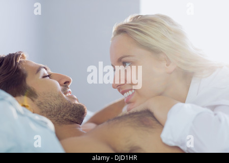 Allegro coppia giovane cuddling nel proprio letto Foto Stock