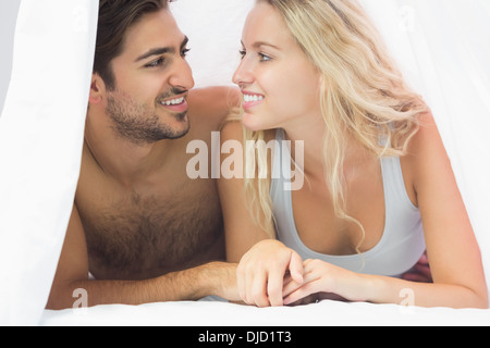 Bella giovane coppia giacente sul letto Foto Stock