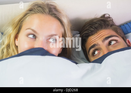 Carino coppia che si nasconde sotto una coperta Foto Stock