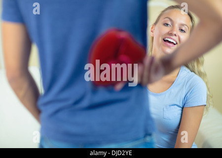 Giovane uomo che nasconde una presente dietro la schiena Foto Stock