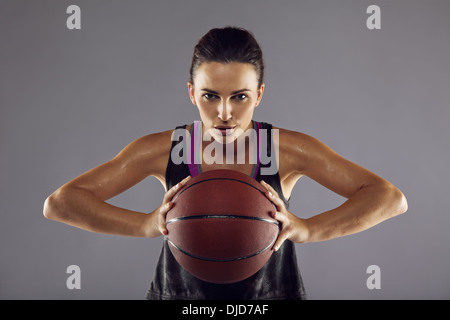 Ritratto di donna felice del giocatore di basket passando la palla. Bella giovane donna in azienda di abbigliamento sportswear basket Foto Stock