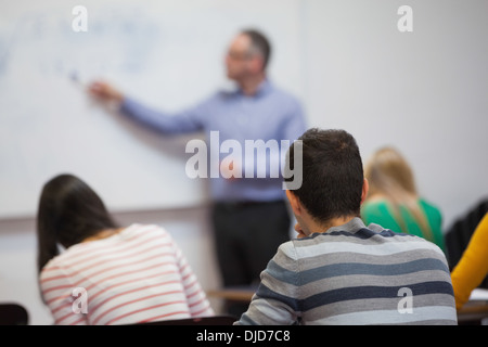 Gli studenti ascolto al loro insegnante in classe Foto Stock