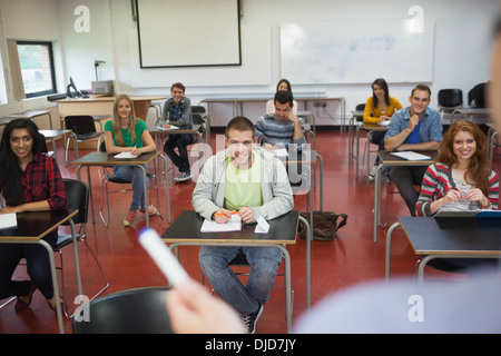 Gli studenti ascolto al loro insegnante in classe Foto Stock