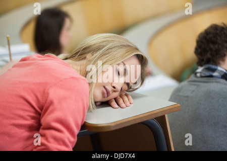 Studente bionda dorme in un aula magna Foto Stock