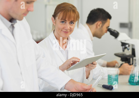 Femmina scienziato maturo utilizzando il suo tablet in laboratorio Foto Stock