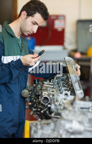 Focalizzato repairman la riparazione di un motore Foto Stock