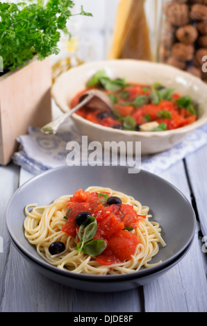 Spaghetti con sugo di pomodoro grigliate con olive nere e foglie di basilico, studio shot Foto Stock