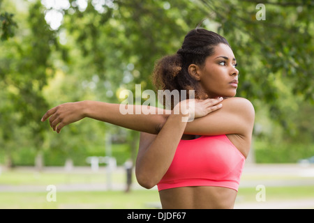 Gravi sano giovane donna stretching la mano in posizione di parcheggio Foto Stock