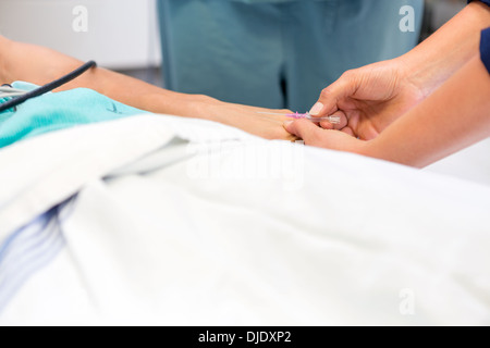 L'infermiere inserisce l'ago nel paziente in corrispondenza del nervo ospedale Foto Stock