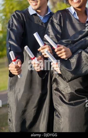 Gli studenti titolari di diplomi sul giorno di graduazione In collegio Foto Stock