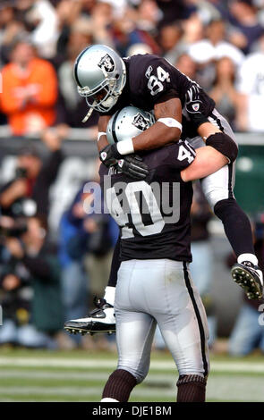 Jan 12, 2003; Oakland, CA, Stati Uniti d'America; Oakland Raiders ampia ricevitore Jerry Porter è issato in aria dal compagno di squadra John Ritchie dopo Porter ha segnato un touchdown nel terzo quarto trimestre del loro AFC playoff divisionale gioco su Domenica, 12 Gennaio 2003 da Network Associates Coliseum di Oakland, California I raider ha vinto il gioco 30-10. Foto Stock