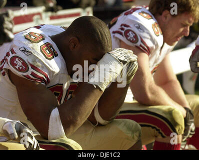 Jan 12, 2003; Tampa Bay, FL, Stati Uniti d'America; San Francisco quaranta Niners Andre Carter e John Engelberger (R) SIT sconsolato sul banco nei secondi finali della loro divisione gioco di spareggio contro i bucanieri di Tampa domenica gennaio 12,2003 presso Raymond James Stadium di Tampa, Flordia. Il Bucs ha vinto 31-6. Foto Stock