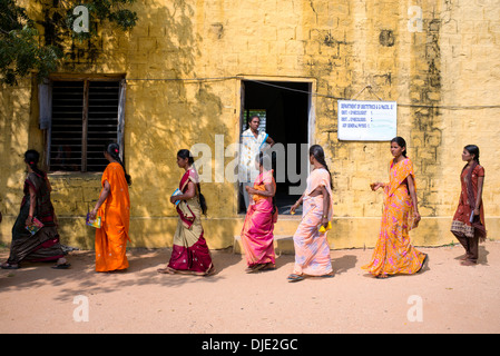 Le donne indiane i pazienti a camminare verso una clinica al Sri Sathya Sai Baba mobile ospedale outreach. Andhra Pradesh, India. Foto Stock