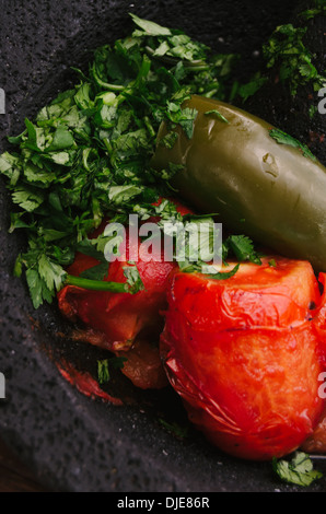 Autentica salsa messicana essendo preparato su molcajete. Foto Stock