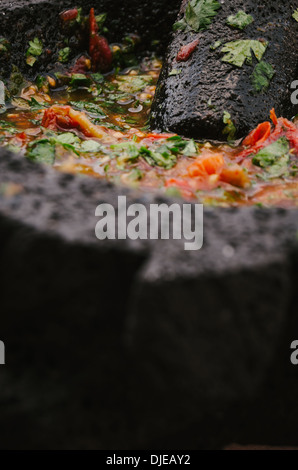 Autentica salsa messicana essendo preparato su molcajete. Foto Stock