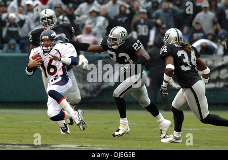 Oct 17, 2004; Oakland, CA, Stati Uniti d'America; NFL Football: quarterback Denver Jake Plummer inizia a scorrere dopo una lunga corsa per un primo verso il basso nel terzo trimestre. #23 per i raider Marques Anderson insegue. Foto scattata durante i raider vs Broncos gioco presso la Network Associates Coliseum. Foto Stock