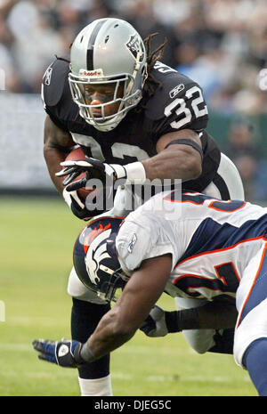 Oct 17, 2004; Oakland, CA, Stati Uniti d'America; NFL Football: #32 Zack Crockett viene affrontato su un guadagno di breve da #52 D.J. Williams nel primo trimestre. Foto scattata durante i raider vs Broncos gioco presso la Network Associates Coliseum. Foto Stock