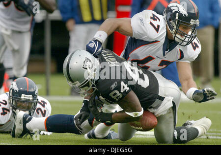 Oct 17, 2004; Oakland, CA, Stati Uniti d'America; NFL Football: Raider Jerry Porter fumbles la palla vicino alla linea di Raider per un fatturato nel secondo trimestre. #47 John Lynch ha battuto la palla fuori. Il gioco è stato il punto di svolta per la 31 a 3 perdita. # Foto scattata durante i raider vs Broncos gioco presso la Network Associates Coliseum. Foto Stock