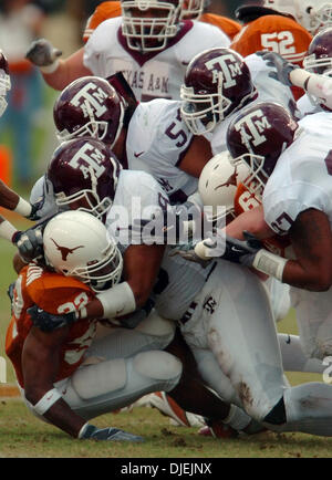 Nov 26, 2004; Austin, TX, Stati Uniti d'America; NCAA College Football - (Texas A&M vs Texas ) la difesa Aggies piste fino a portare verso il basso Longhorns running back Cedric Benson nella prima metà Venerdì, 26 novembre 2004 a Darrell K. Royal-Texas Memorial Stadium a Jamail campo. I giocatori del Longhorn battere il Aggies, 26-13. Foto Stock