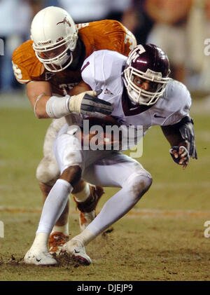 Nov 26, 2004; Austin, TX, Stati Uniti d'America; NCAA College Football - (Texas A&M Aggies vs Texas Longhorns) Aggies quarterback Reggie McNeal è saccheggiato da Texas fine Brian Robison nella seconda metà Venerdì, 26 novembre 2004 a Darrell K. Royal-Texas Memorial Stadium a Jamail campo. I giocatori del Longhorn battere il Aggies, 26-13. I giocatori del Longhorn battere il Aggies, 26-13. Foto Stock