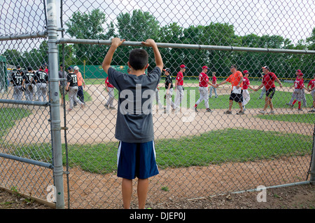 Young Teen boy guarda la squadra di baseball buone pratiche di sportività agitando mani dopo il gioco. St Paul Minnesota MN USA Foto Stock