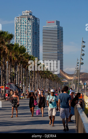 Persone che passeggiano sul lungomare, la spiaggia di Barceloneta, Barcellona Foto Stock