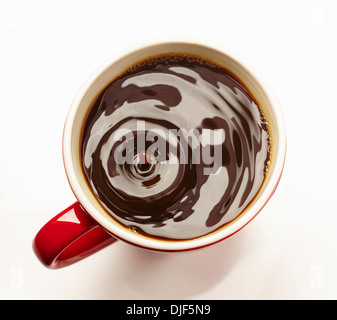 Red tazza di caffè con una goccia caduta su sfondo bianco Foto Stock