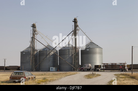 Auto abbandonate e un freightliner semi highway truck parcheggiato a fianco di silos per il grano in mocassino, montana Foto Stock