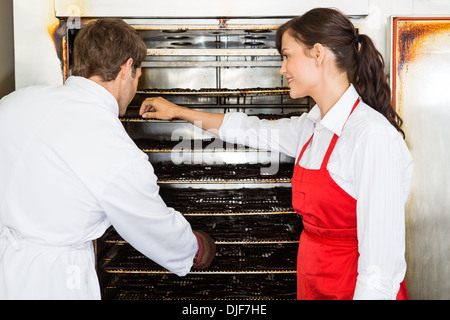 Lavoratori di carne di essiccazione in forno a macelleria Foto Stock