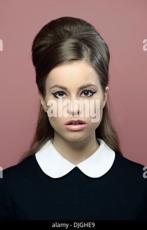 Un bel ritratto di donna vestita di un vintage 60s abito, vintage hairstyle, un vintage fashion concept. Foto Stock