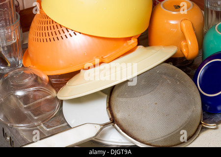 Lavare le piastre colorate, piatti, tazze e bicchieri con un colino, essiccazione vicino al lavandino Foto Stock