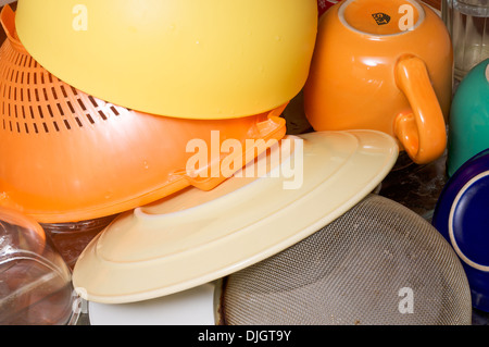 Lavare le piastre colorate, piatti, tazze e bicchieri con un colino, essiccazione vicino al lavandino Foto Stock