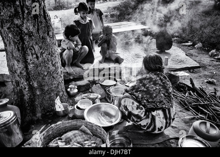 Donna indiana che dosa di cottura per i bambini nelle zone rurali del villaggio indiano street. Andhra Pradesh, India. In bianco e nero. Foto Stock