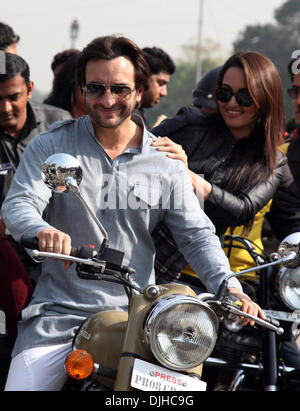 New Delhi, India. 28 Nov, 2013. Bollywood stelle Saif Ali Khan (L, anteriore) e Sonakshi Sinha (R, anteriore) guidare una moto con un obiettivo di promuovere una guida sicura nel corso di un evento promozionale insieme a Delhi Polizia stradale in India Gate in New Delhi, India, nov. 28, 2013. © Xinhua/Alamy Live News Foto Stock