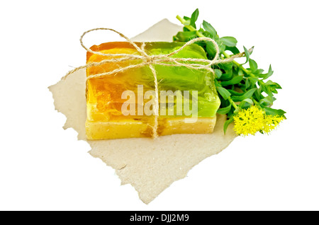Due pezzi di sapone casalingo, legata con lo spago con la Rhodiola rosea fiori su un pezzo di carta isolato su sfondo bianco Foto Stock